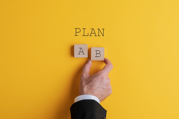 A picture of a person putting blocks down that say ‘plan A’ and ‘plan B